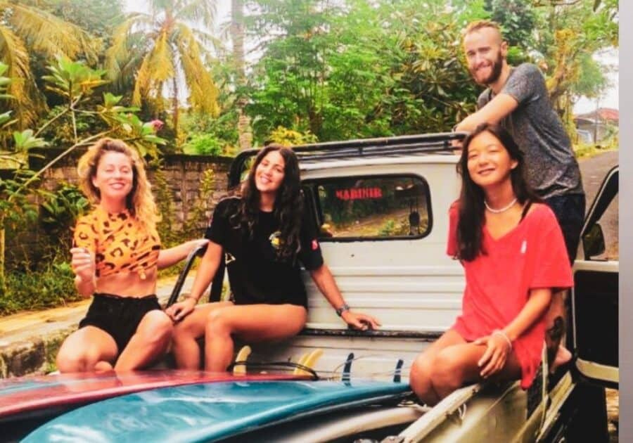 friends wating to go surfing sitting on a truck