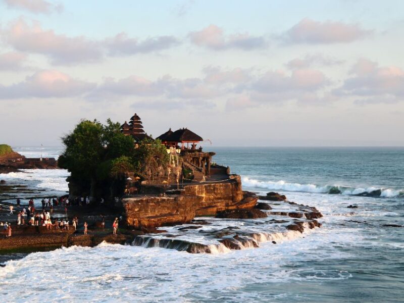 Tanah Lot Temple in Bali on a rocky sea outcrop with waves and coastal views