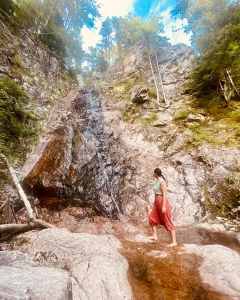 Abi stands at a small waterfall in Kruth