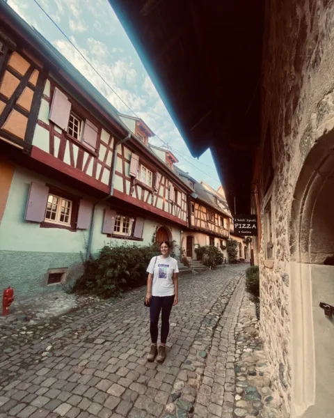 Abi stands in the narrow cobbled streets of Eguisheim is Alsace.