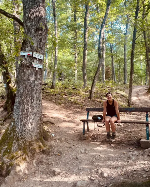 Abi sitting on a bench at a checkpoint along the 3 castles of Ribeauville hike.