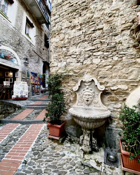 Carugi lanes in Dolceacqua old town, fountain and art shops