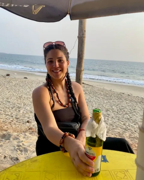 Abi enjoying a beer on Lumley Beach is one of the best things to do in Sierra Leone
