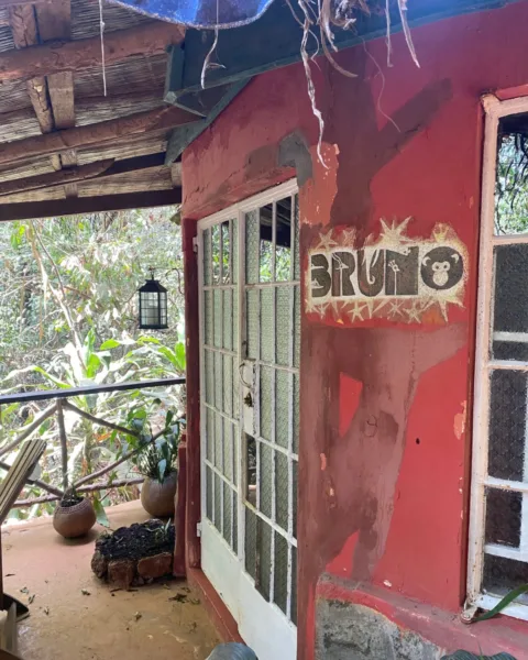 Close up of a red building with french doors onto a patio with the word 'Bruno' on the wall.