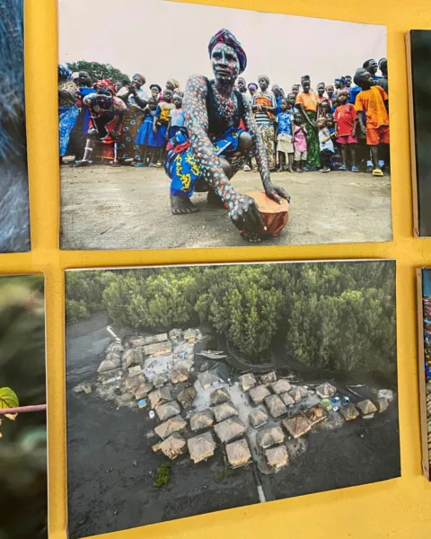 photos on a yellow wall of communities in remote areas of Sierra Leone
