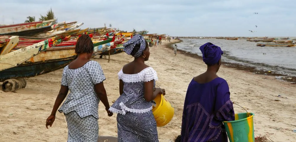 Three women walking on the beach in Sierra Leone