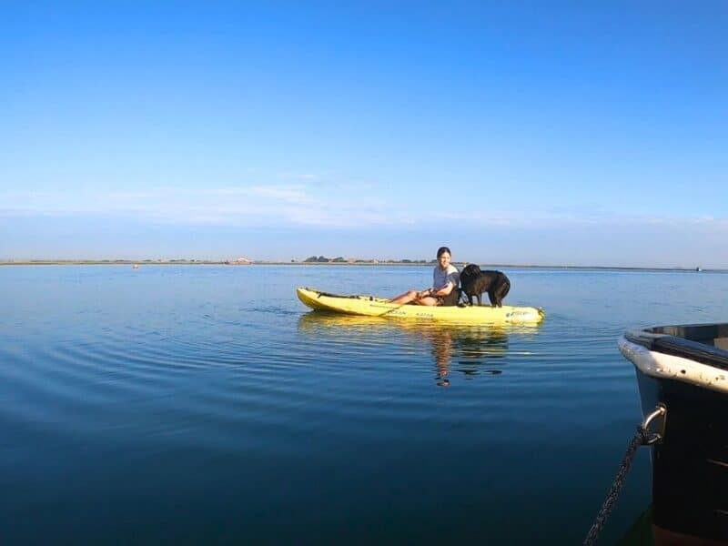 Abi on a kayak with her dog thinking about which is better: travelling alone vs travelling with someone or a pet