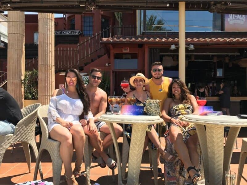 Abi with friends around a table sitting in the sun.