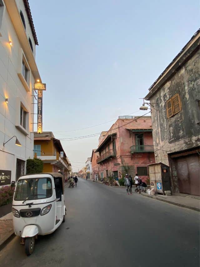 A white tuk-tuk parked on the street in Saint-Louis Island, Senegal
