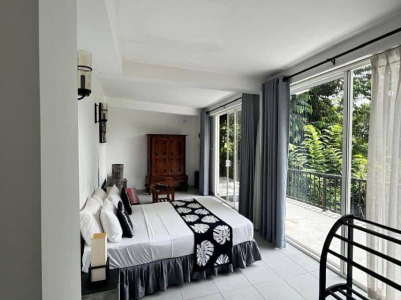Selyna Sky Terrace double suite, Kandy – bright room with sliding glass doors and balcony over jungle hills.