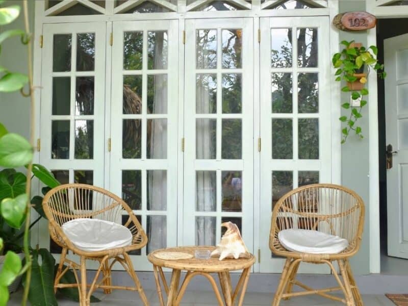 Private veranda with rattan chairs outside a room at Ella Ceylonka in Ella.