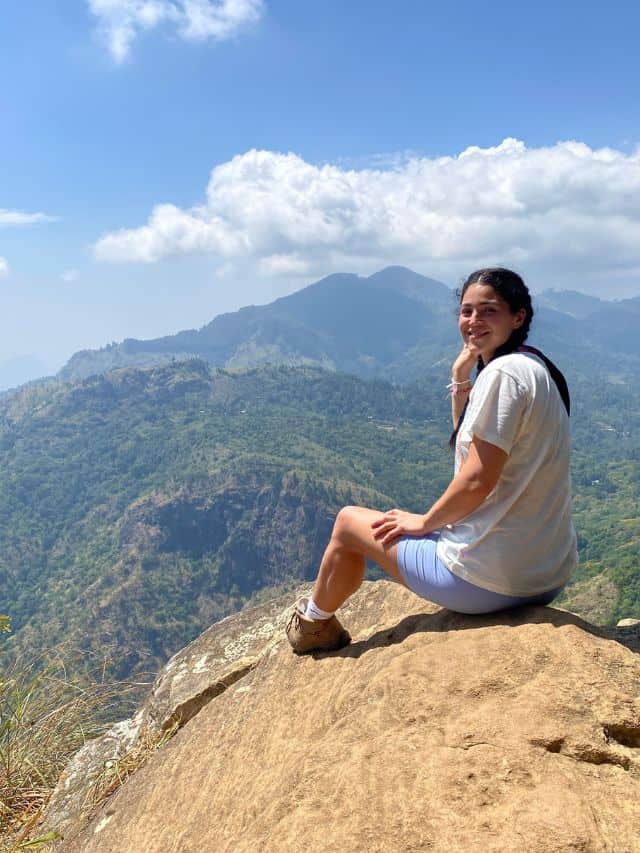 Woman sitting at a viewpoint on Ella Rock in Sri Lanka which is one of the most popular things to do in Ella