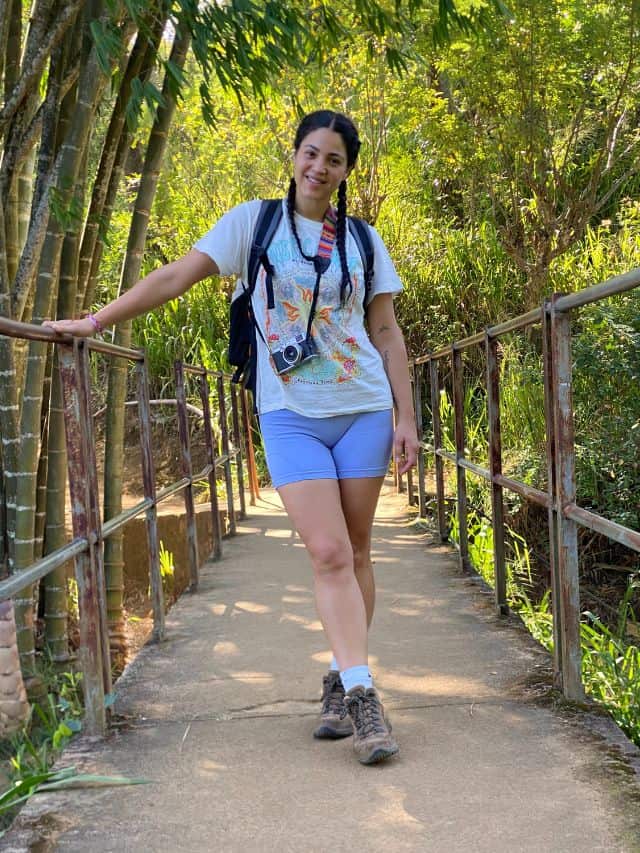 Traveller standing on a small bridge surrounded by bamboo and greenery near Ella.