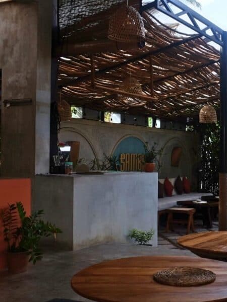 Interior of Samba Ahangama with wooden tables, woven lamps and a relaxed tropical café setting.