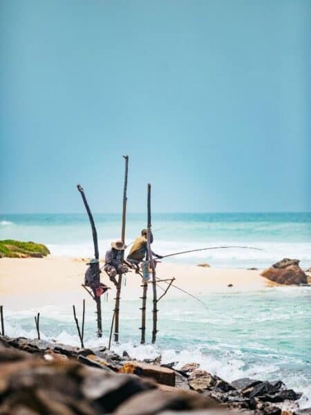 Stilt fishermen near Koggala sitting above the waves