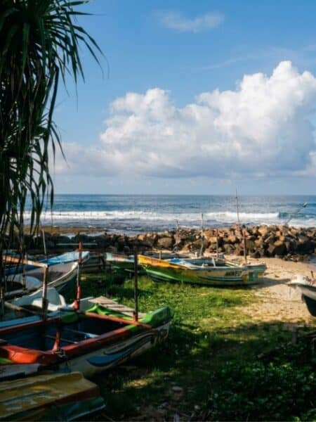 Fishing boats beside the rocky coastline in Ahangama with waves breaking offshore