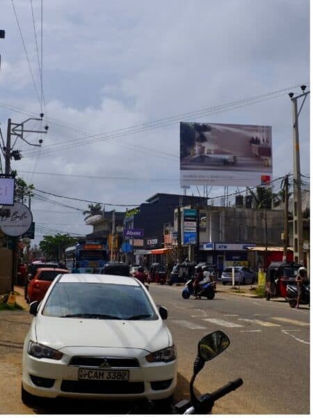 Busy main road through Ahangama with cars, tuk-tuks and shopfronts