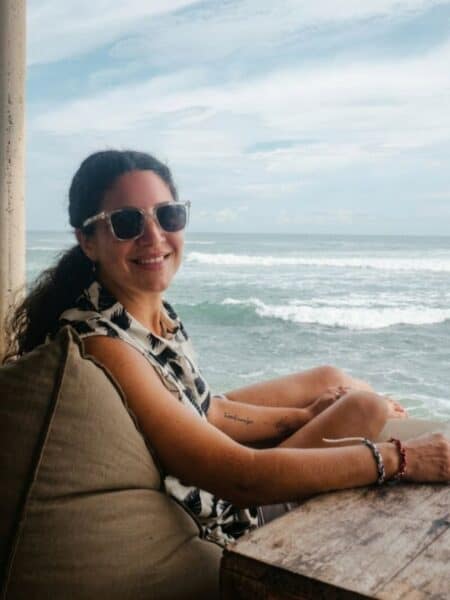 Traveller sitting at an oceanfront café in Ahangama with waves behind — is Ahangama worth visiting for oceanfront views?