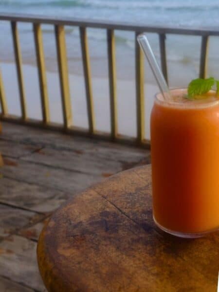 Fresh juice on a table with ocean in the background.