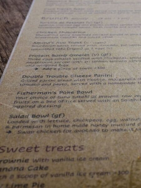 Close-up of a café menu at one of the cafes in Ahangama, showing brunch and sweet treat options.