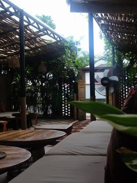 Cosy indoor seating area at one of the cafes in Ahangama, with tropical plants and wooden tables.