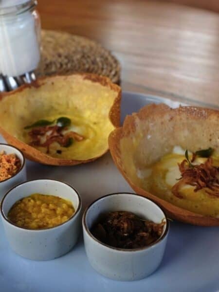 Close-up of egg hoppers with dhal, onion sambol and coconut sambol in Ahangama.