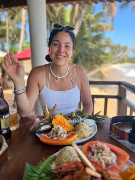 Woman eating grilled fish at Coconut Palm Beach Restaurant near Dickwella Bay Beach