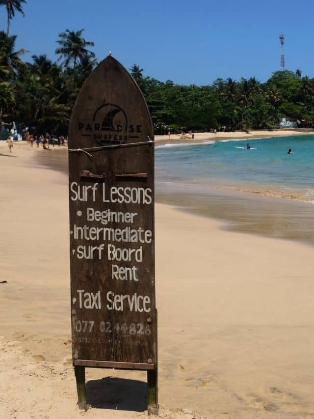 Surf lesson sign on the sand at Hiriketiya Beach Sri Lanka