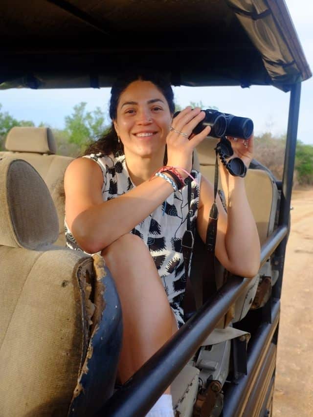 Traveller using binoculars inside a safari jeep during an Ella to Ahangama Safari transfer in Sri Lanka