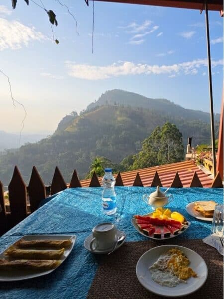 Breakfast with mountain views in Ella, including fruit, tea and traditional Sri Lankan food.
