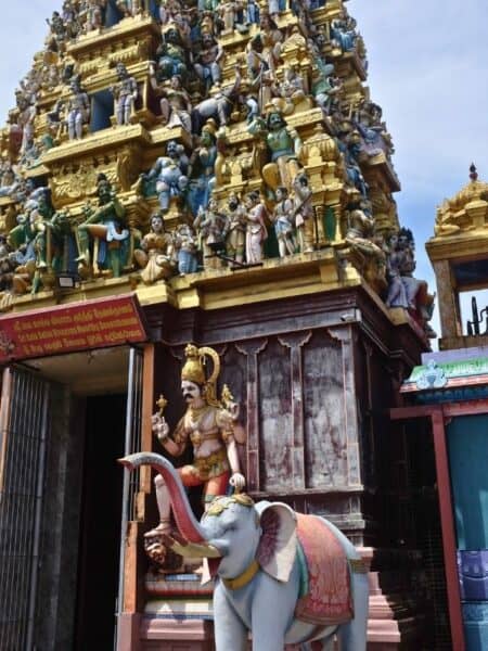 Colourful Hindu temple tower in Colombo covered with detailed statues and an elephant figure.