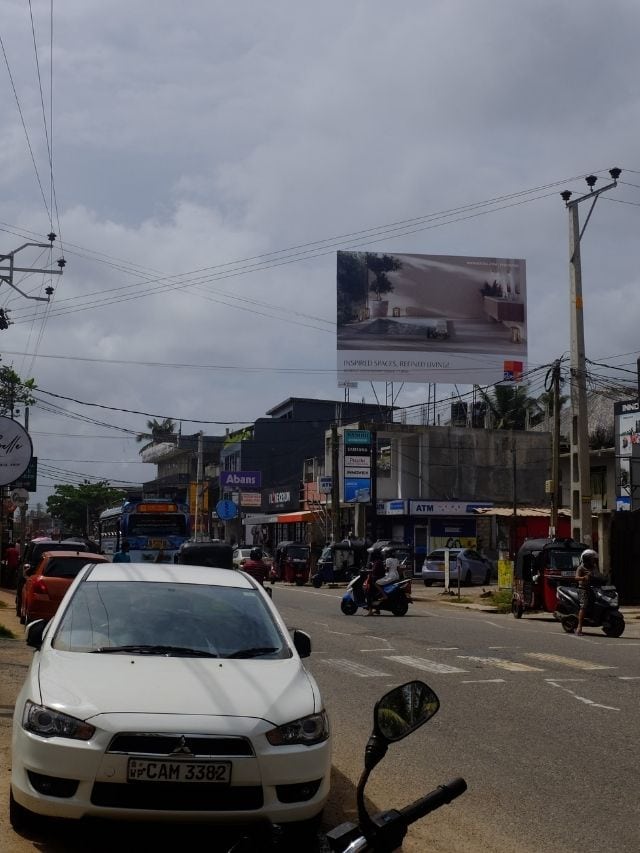 Busy road in Ahangama with cars, scooters, tuk-tuks and stormy skies on Sri Lanka’s south coast.