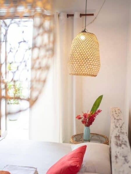 Boho bedroom detail at 7BD Surf House in Sri Lanka with rattan lamps and white bedding