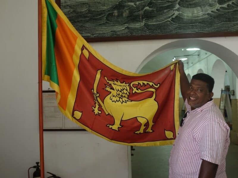 Guide holding the Sri Lankan flag inside the Maritime Museum in Colombo