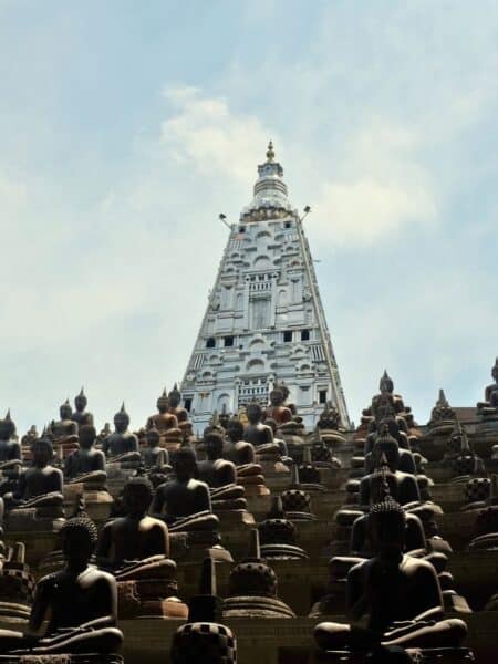 Buddha statues and white tower at Gangaramaya Temple in Colombo