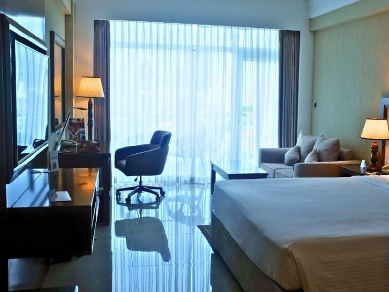 Bright Premier Room at Marino Beach Colombo with a king bed, desk, sofa and balcony doors.