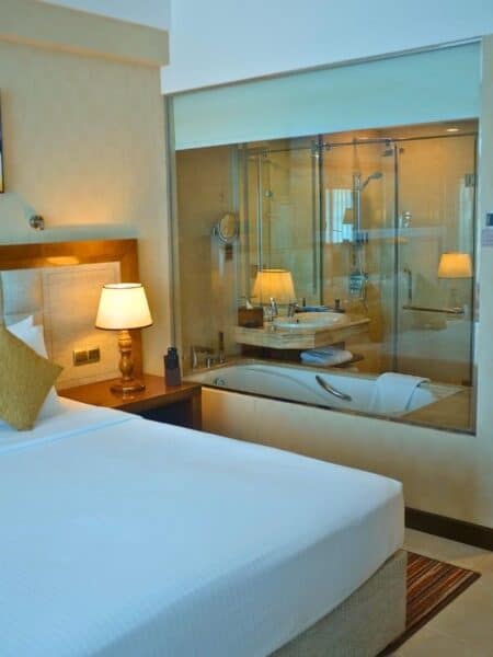 Marino Beach Colombo room with king bed and glass bathroom wall beside the bedroom