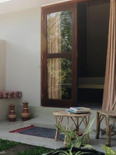 Outdoor seating area with rattan chairs and garden views at Mellow Hostel.