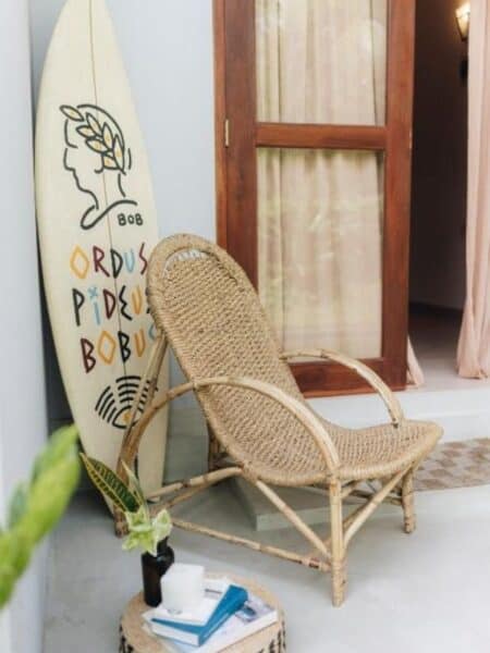 Surfboard and rattan chair outside a private room at Mellow Hostel in Sri Lanka.